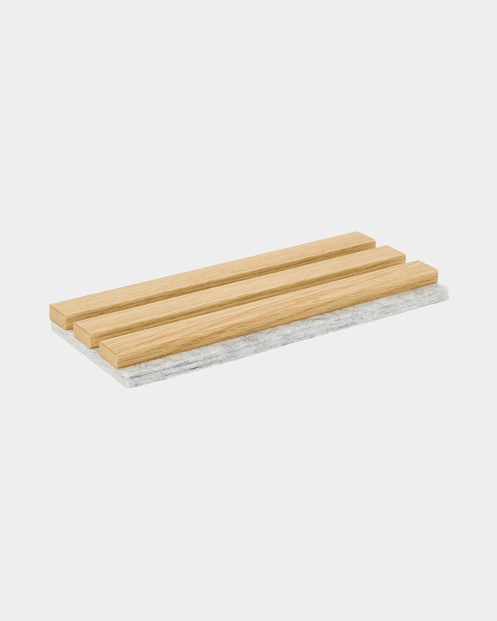 Próbka WoodUpp Akupanel z lamelami o wyglądzie drewna Southern Oak na filcowej podstawie grey, pokazująca fragment Panel akustyczny w nordyckim stylu marki.
